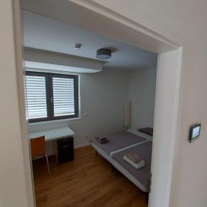 巴特贝林根Modernes Apartment的客房设有床、书桌和窗户。