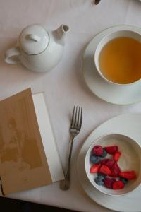枫丹白露Hôtel de Cavoye的一张桌子,上面放着一盘水果和一杯茶