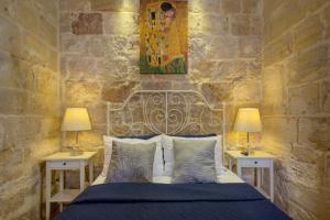 瓦莱塔Valletta Waterfront Villa with Pool and Jacuzzi的一间卧室配有一张床、两个床头柜和两盏灯。