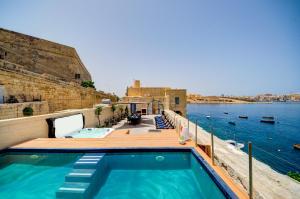 瓦莱塔Valletta Waterfront Villa with Pool and Jacuzzi的水边甲板上的游泳池