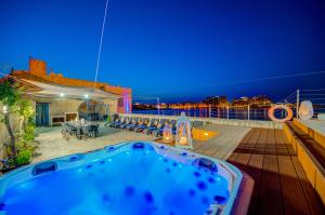 瓦莱塔Valletta Waterfront Villa with Pool and Jacuzzi的夜间在游轮甲板上的热水浴池