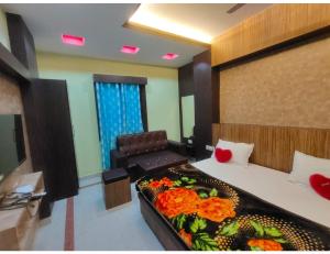 Sītāpur MūāfiHotel Anuj Residency, Chitrakoot的一间房间,里面设有一张床和一张鲜花椅