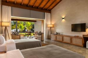 本托塔Villa Thamburu, Bentota的一间卧室配有两张床和一台平面电视