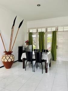 巴图Villa Dedaun Batu的一间设有桌子和绿色窗帘的用餐室