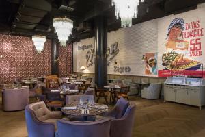 萨格勒布Canopy by Hilton Zagreb City Centre的一间带桌椅和大型壁画的餐厅