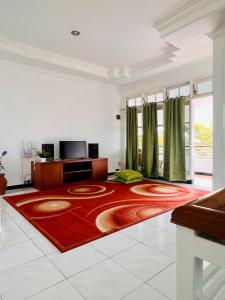 巴图Villa Dedaun Batu的一间铺有红色地毯的客厅