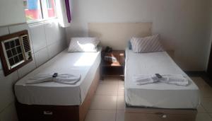圣贝尔纳多-杜坎普Hotel Orquídea -Rudge Ramos (Adults only)的客房内的两张床和毛巾