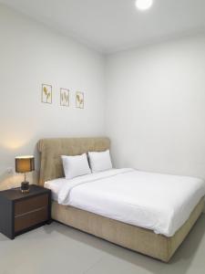 明古鲁省Uresidence Bengkulu的一间白色卧室,配有床和床头柜