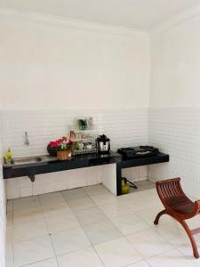 巴图Villa Dedaun Batu的厨房配有带水槽和椅子的柜台