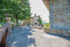 乌尔比诺Suite con Bagno in villa esclusiva - Urbino的一座石头建筑,设有围栏和桌椅
