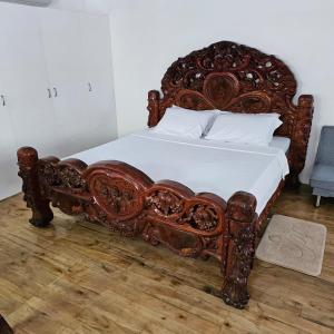 ValenciaA's Place - Casaroro的一张带白色床单和枕头的大型木制床