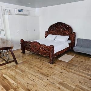 ValenciaA's Place - Casaroro的一间卧室配有一张大型木床和椅子