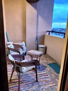 布尔加斯Lazuren Bryag Lux suite的带阳台的客房配有2把椅子和一张桌子