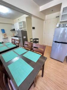宿务1-BR unit in IT Park Cebu City的厨房配有桌椅和冰箱。