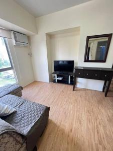 宿务1-BR unit in IT Park Cebu City的一间卧室配有一张床、一张书桌和一面镜子