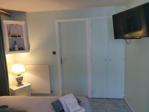 CampsegretLes Tamaris的卧室配有一张床,墙上配有电视。