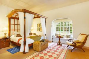 斋浦尔欧贝罗伊拉雅维拉斋浦尔酒店的卧室配有床、椅子和窗户。