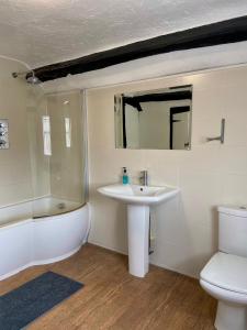 金斯兰利国王洛奇酒店的一间带水槽、浴缸和卫生间的浴室