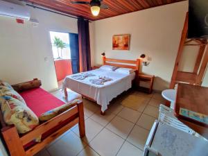 乌巴图巴卡萨纳普拉亚旅馆 的一间卧室配有一张床和一个沙发