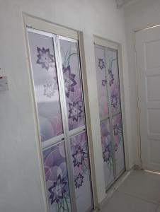 万挠SERI BAKAWALI HOMESTAY的一间设有两扇玻璃门的房间,鲜花盛开