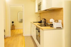 毕尔巴鄂BILBAO NORTH SHORE APARTMENTS 6的厨房配有白色橱柜和台面