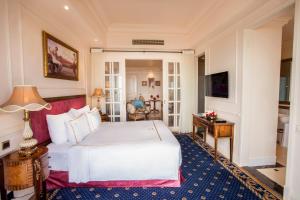 头顿The IMPERIAL Vung Tau Hotel的卧室配有一张白色的大床和一张桌子