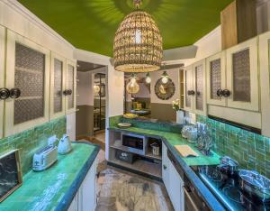 马拉喀什Maison Maria Palmeraie的厨房配有绿色台面和吊灯