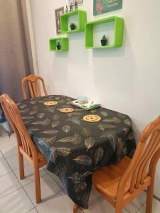米里Taman Tunku Miri Budget Homestay的餐桌、两把椅子、一张桌子和一张桌布