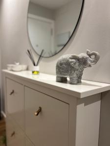 阿罗萨新镇Apartamento Arousa Mar的象在镜子前的台面上雕像