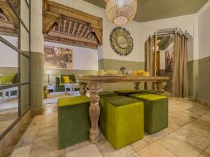 马拉喀什Maison Maria Palmeraie的一间带桌子和绿色凳子的用餐室