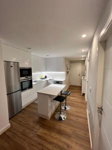 阿罗萨新镇Apartamento Arousa Mar的厨房配有白色橱柜和白色台面