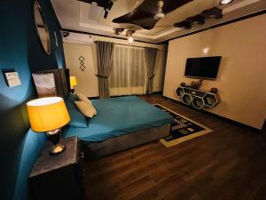 伊斯兰堡The Comfort Lodge的配有床、灯和电视的房间
