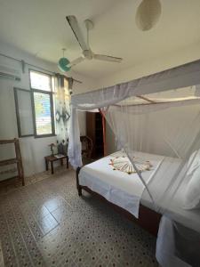 帕杰Mauwa House的一间卧室配有一张床和吊扇