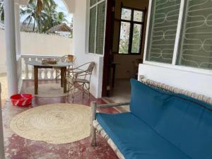 帕杰Mauwa House的客厅配有蓝色的沙发和桌子