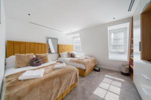伦敦Marble Arch Penthouse 3 Bed的一间卧室设有两张床和两个窗户。
