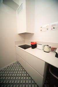 巴塞罗那Private room By BCN Center的厨房配有白色橱柜和黑色水槽