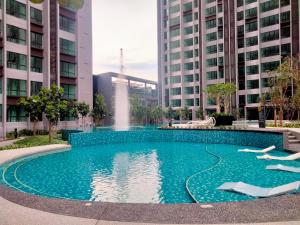 吉隆坡Cubic Botanical Suites Bangsar South by HomeBrickz的两个高楼中间的一个游泳池