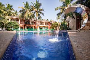 巴加Goa Chillout Apartment - 1BHK, Baga的一座大楼前的游泳池,带喷泉