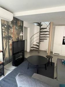 希迈Chimay : la Chambre Verte de la Grand Place的一间带桌子和螺旋楼梯的客厅