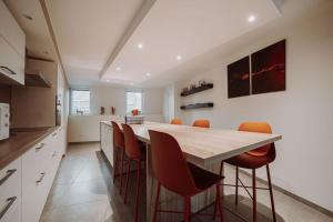 希迈Chimay : La Grande Réserve的厨房配有木桌和橙色椅子