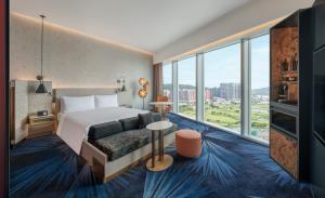 澳门W Macau - Studio City的酒店客房设有一张床和一个大窗户