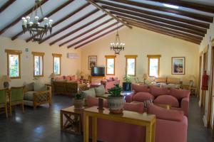 皮卡Cabañas La Huayca - Caja Los Andes的一间设有粉红色椅子和桌子的等候室,窗户