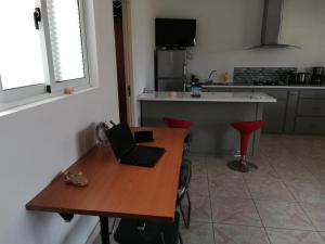 明德卢Casa Yô的厨房配有木桌和笔记本电脑