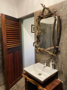 莫尔吉姆Jardin d'Ulysse & Hard Rock的浴室设有白色水槽和镜子
