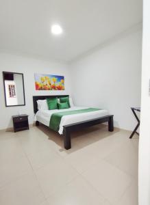 巴耶杜帕尔Hotel Orquídea Real的一间卧室配有一张带绿色枕头的床
