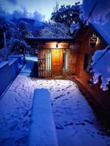 圣卡洛斯-德巴里洛切Cuatro Cerros Hostel的夜晚有门在雪中的房子