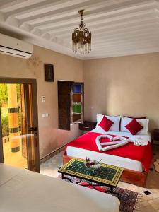 马拉喀什Riad Rime Garden Marrakech的一间卧室配有一张红色的床和吊灯。