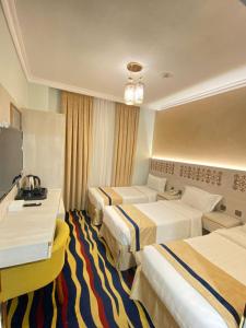 麦地那Dar Al Naem Hotel的酒店客房设有三张床和电视。