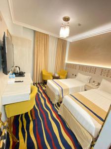 麦地那Dar Al Naem Hotel的酒店客房设有两张床和电视。