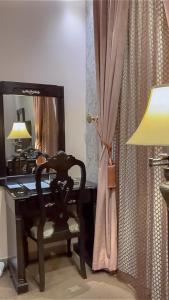 奈季兰Levant Hotel的一张桌子、椅子、灯和镜子